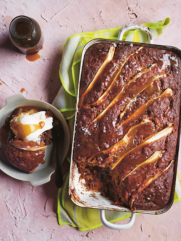 A large baking dish with a parsnip sticky date pudding and bowl with ice cream. 